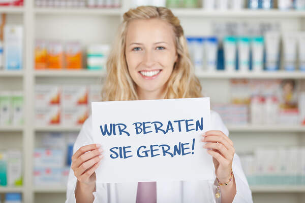 Apothekerin hält Schild hoch