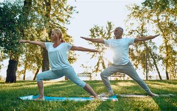 Mann und Frau bei der Dehnung beim Yoga in der Natur