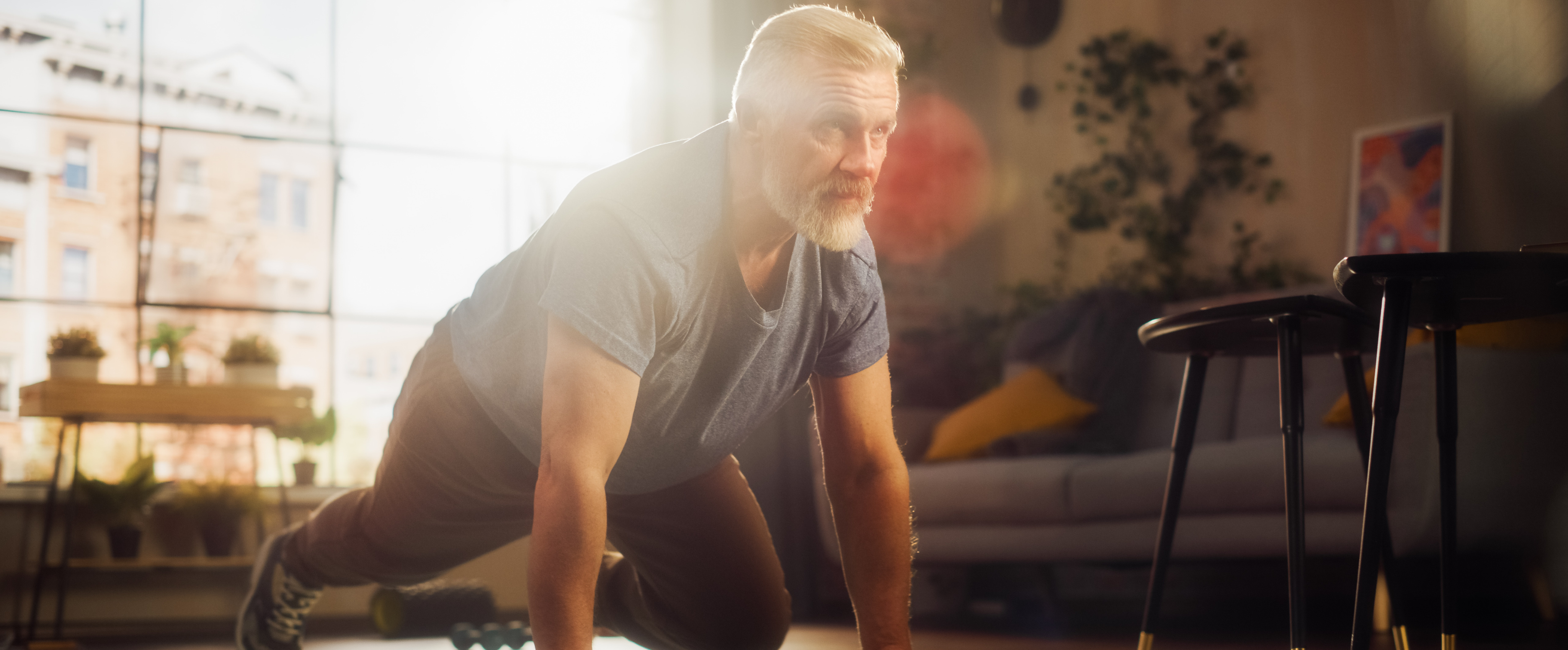 Ein Mann (mittig) macht Liegestütz auf einer grünen Fitnessmatte.