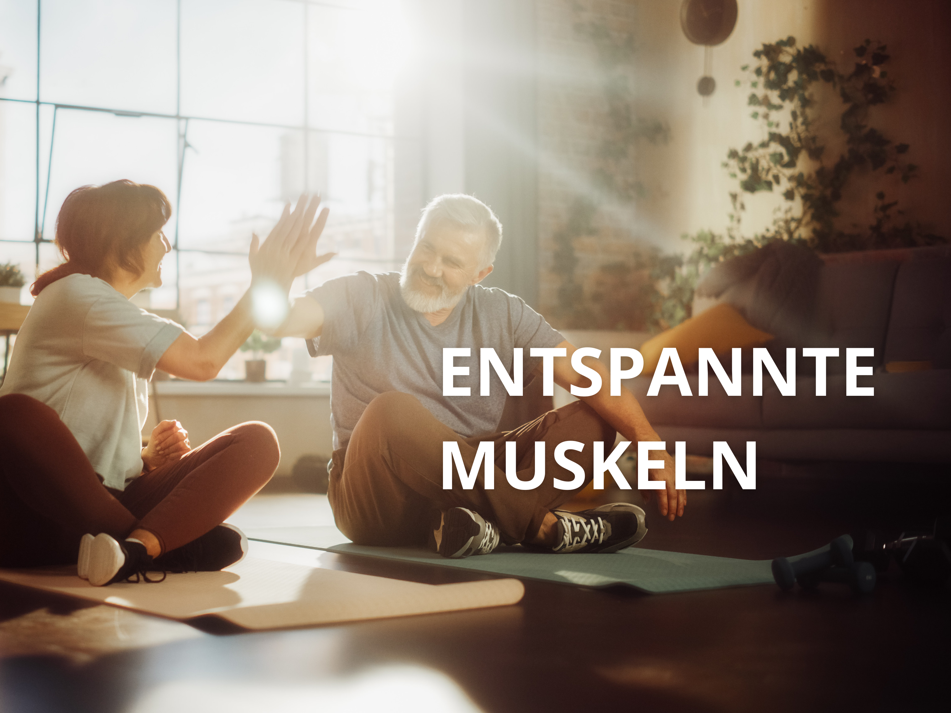 Eine Frau (links) und ein Mann (rechts) machen Yogaübungen im Wohnzimmer und heben dabei den rechten Arm um abzuklatschen.